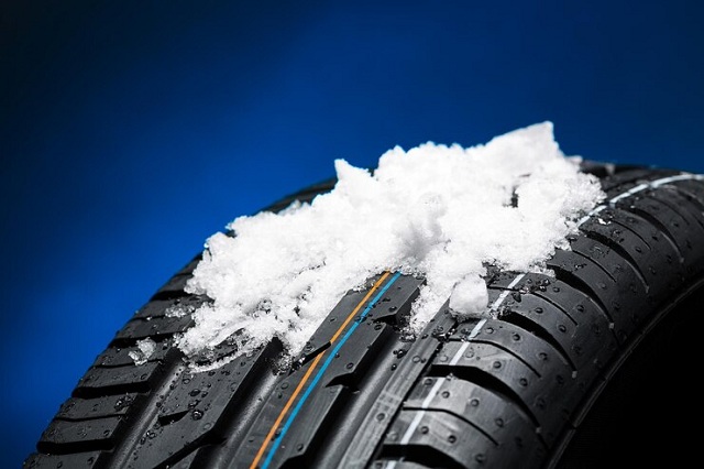 Pneu avec tas de neige hiver sur fond noir bleu