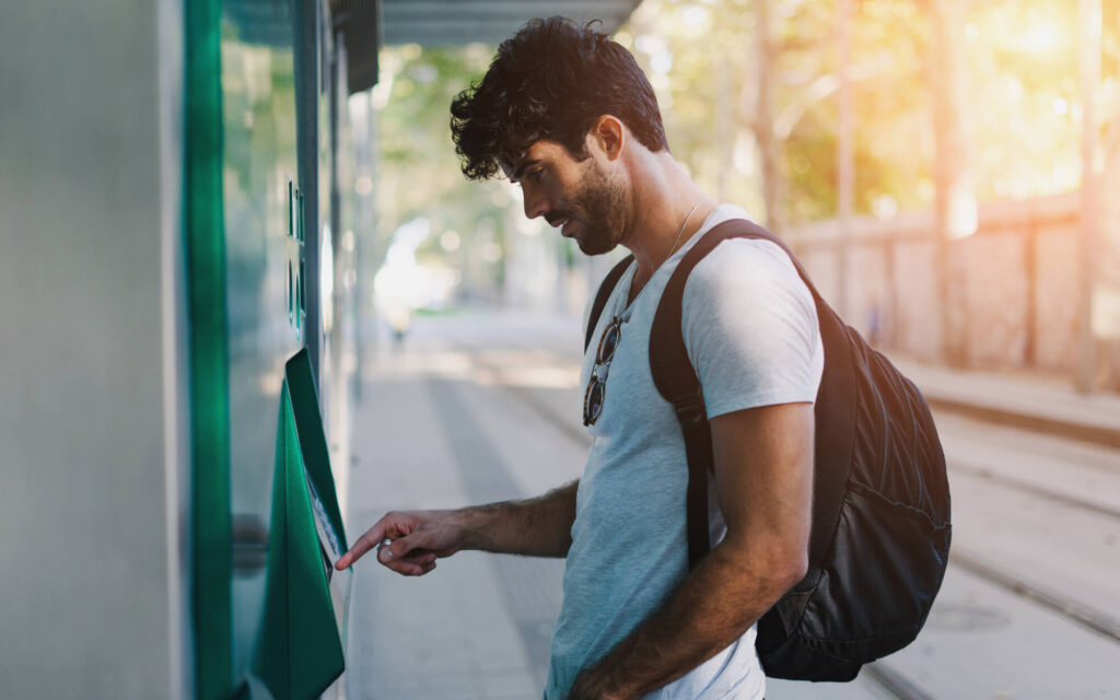 Un homme en train de retirer sur un distributeur automatique