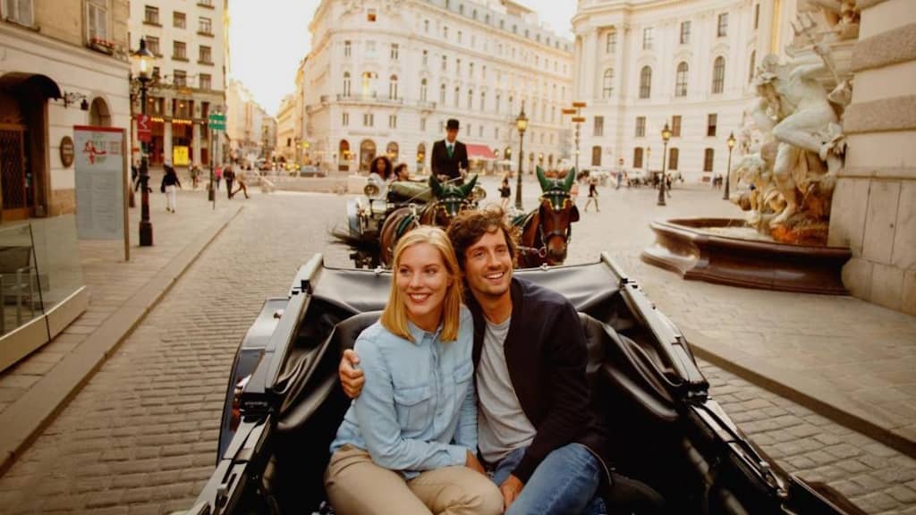 un couple amoureux visite Vienne en calèche