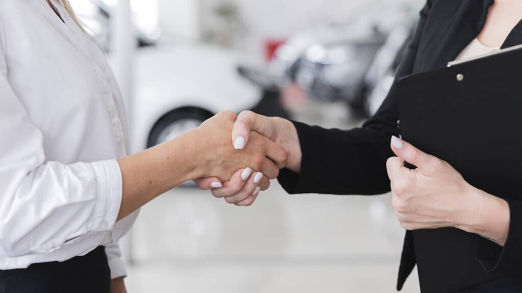femmes serrant mains contrat location voiture