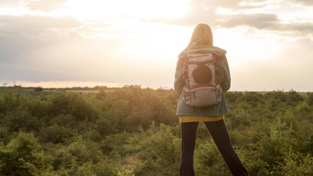 femme sac à dos coucher de soleil