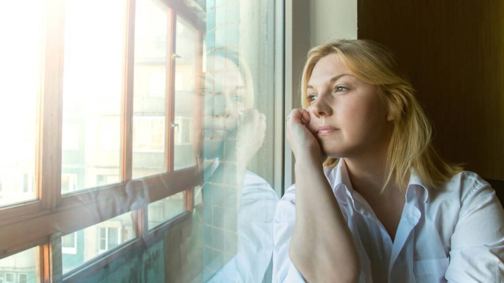 femme songeuse regarde fenetre