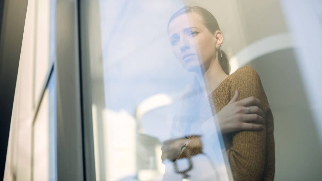 femme triste regarde fenetre