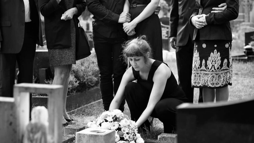 femme depose fleur tombe