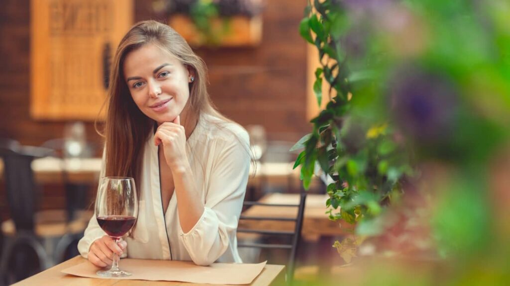 femme seule boit verre de vin