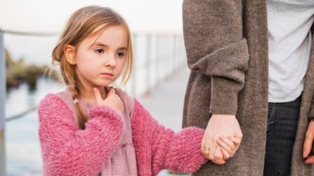 Faut-il forcer un enfant à faire des activités ? Voici quand il vaut mieux insister et quand il faut respecter son rythme fille timide tient main parent