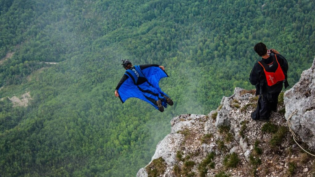 hommes saut falaise wingsuit