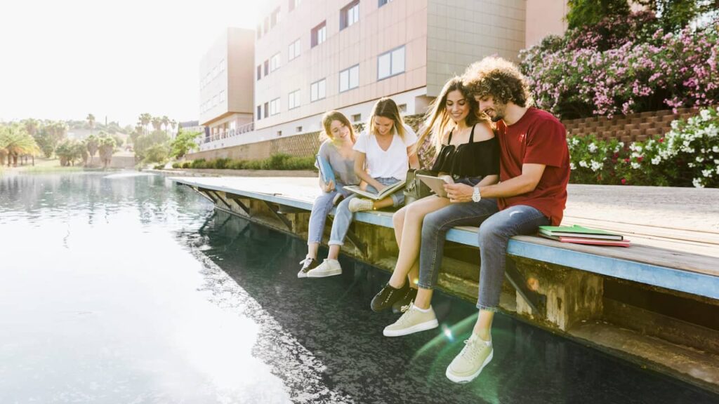 groupe etudiants bord eau livres